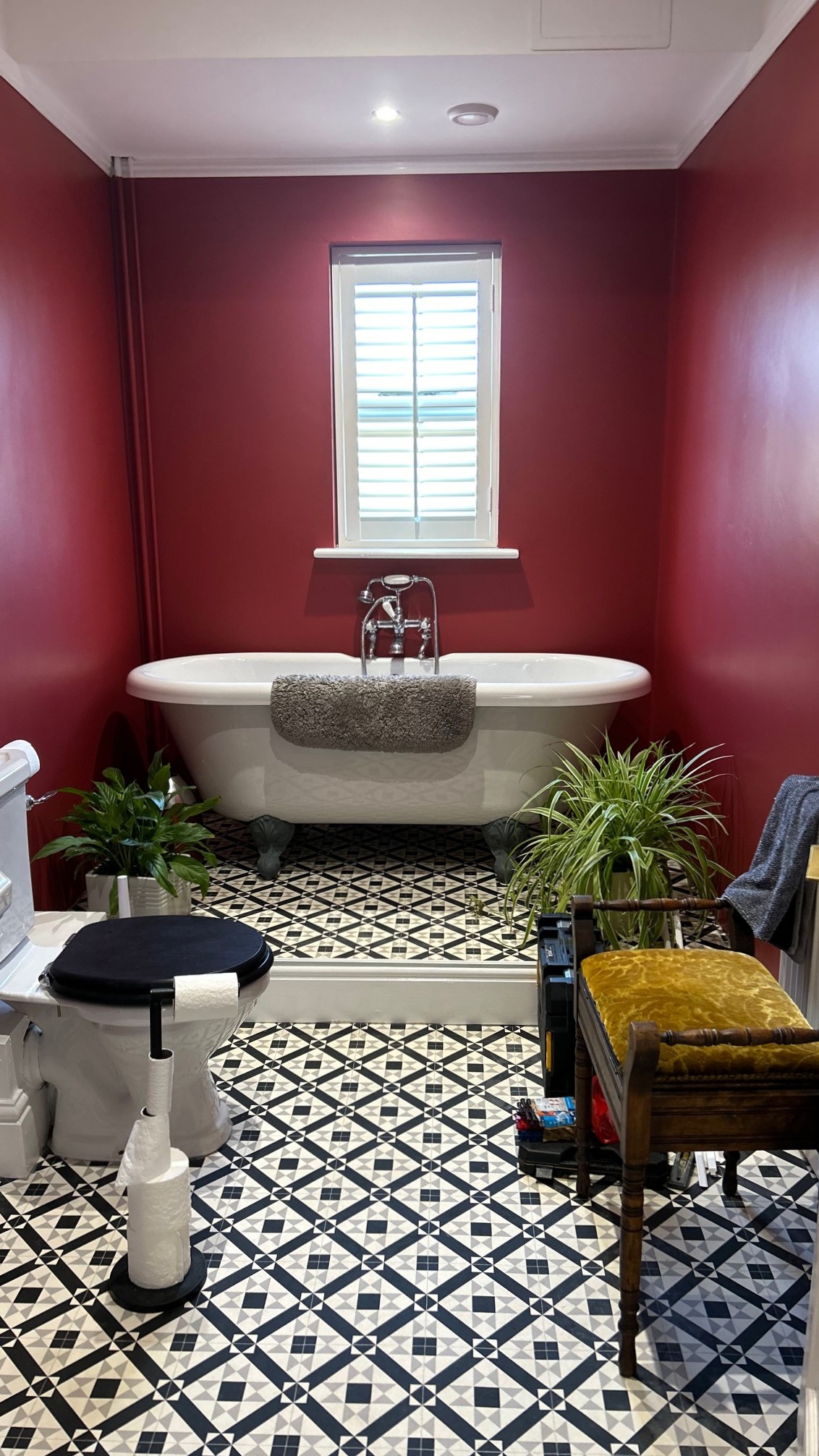 Completed bathroom with red walls, skirting boards, and tile flooring
