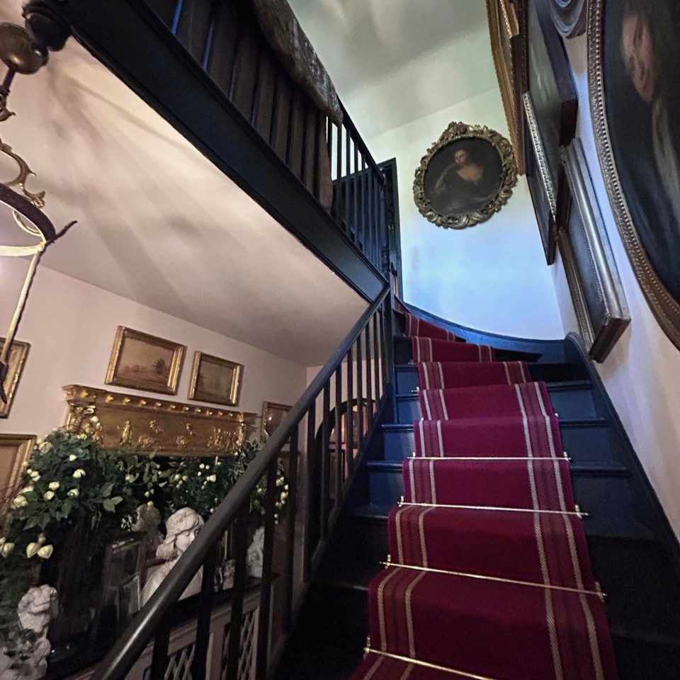 Finished staircase with black bannisters and red carpet runner
